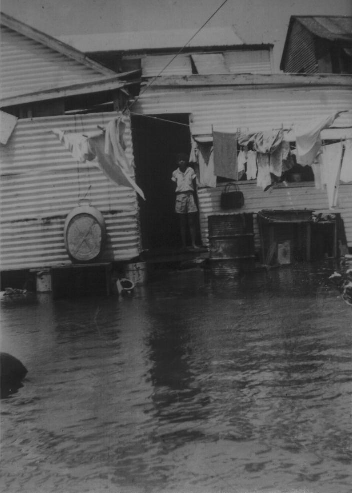 Image of a man standing in a doorway surrounded by sea water. 